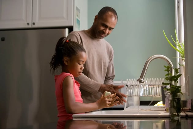 Father washing hands with daughter