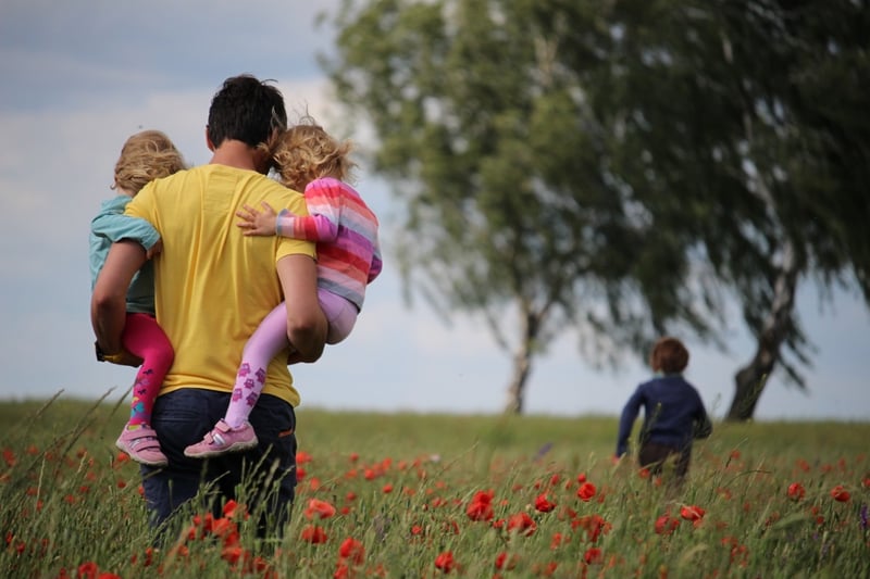 dad-holding-two-kids-field-1