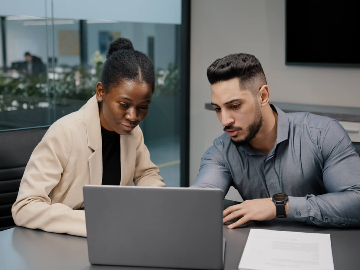 man and woman sitting at laptop