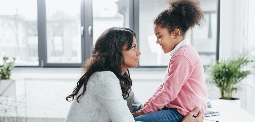 Mother and daughter looking toward each other smiling 